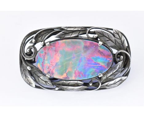 Australian Art Nouveau silver opal doublet brooch. The brooch set with a large oval opal doublet exhibiting a full spectrum p