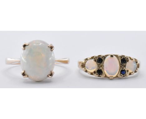 Two 9ct gold and opal rings. One having an oval opal stone prong set to the head. The other ring being set with three opal ca