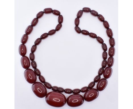 A vintage cherry bakelite necklace having graduating oval red coloured beads. Measures 70cm. Weight 56.2g.&nbsp;