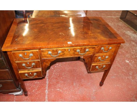 An early 20th century walnut and crossbanded desk, with seven drawers 107cm wide 