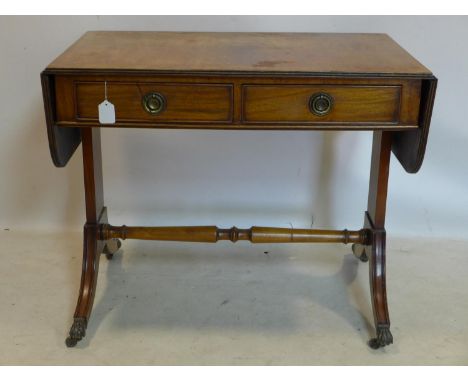 An Edwardian Georgian style mahogany cross-banded sofa table, with 2 drawers, raised on splayed legs, lion paw feet and casto