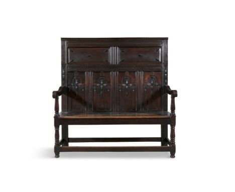 AN 19TH CENTURY OAK HALL BENCH  with tall panelled back, carved with series of niches and geometric decoration, above solid r