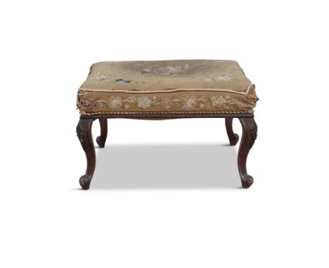 A VICTORIAN CARVED MAHOGANY FOOTSTOOL,  with distressed tapestry covering The top 63 x 54cm     Provenance: Drummin House, Ca