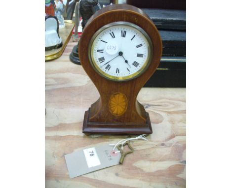 An Edwardian inlaid mahogany balloon clock with a white enamel dial and Roman numerals.