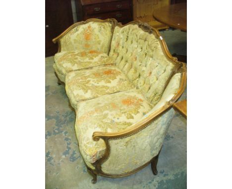 A 20th century French walnut serpentine settee with a button back , cabriole front legs with a carved apron.