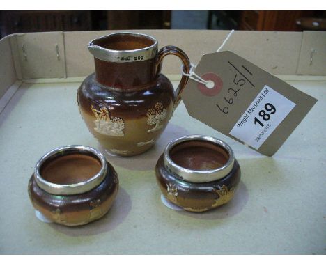 A Pair of Chester hallmarked silver rimmed Doulton stoneware salts and a miniature hunting jug. (3) CONDITION REPORT: Jug - g