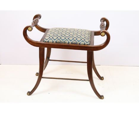 19th Century Regency music stool having carved twist handles with gilt rosette detailing, drop in seat raised on scrolled leg