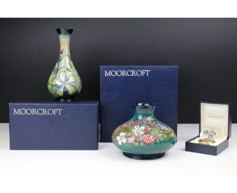 Two boxed Moorcroft pottery vases to include a Carousel squat vase (11cm tall), and a Hypericum baluster vase, plus a boxed M