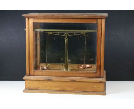 Set of brass scales with copper pans, one depicting the Commonwealth Stadium, Edmonton, Alberta, housed within a glazed woode