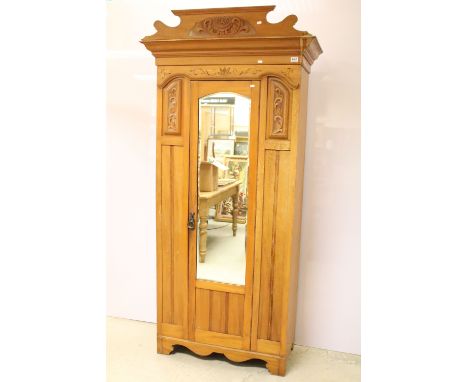 Early 20th century carved single wardrobe, with carved pediment above single mirrored door, with Art Nouveau style swing hand