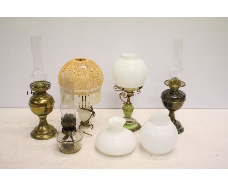 Two 19th Century Victorian oil lamps having milk glass shades together with a carved stone lamp base, and green glass oil lam