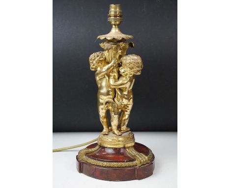 Gilt metal table lamp modelled as two putto, with a red marble base with gilt metal mounts (detached) 37cm high 