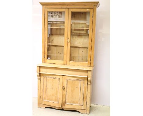 Victorian pine dresser, the upper section with two glazed doors and two shelves, above two panelled doors with shelf to the i