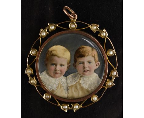An early 20th century seed pearl and gold mounted painted portrait miniature pendant, two little boys with lace frilly collar