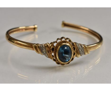 A hollow topaz and diamond accented 9ct gold bangle, stamped 375, import marks worn, 9.6g gross, cased
