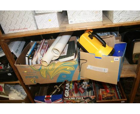 A shelf of books, including Halogen lantern and posters 