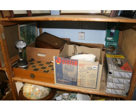 A shelf of miscellaneous , including china and two dynamo lanterns