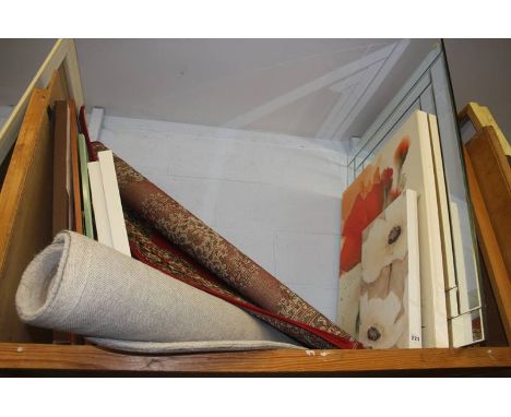 A shelf of canvas prints, mirrors and rugs