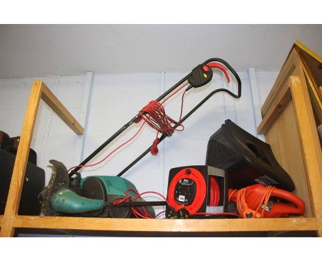 A shelf of gardening equipment, including lawnmower and strimmer