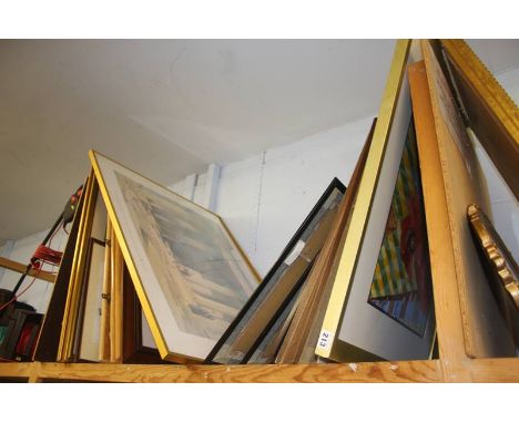 A shelf of miscellaneous framed pictures and prints