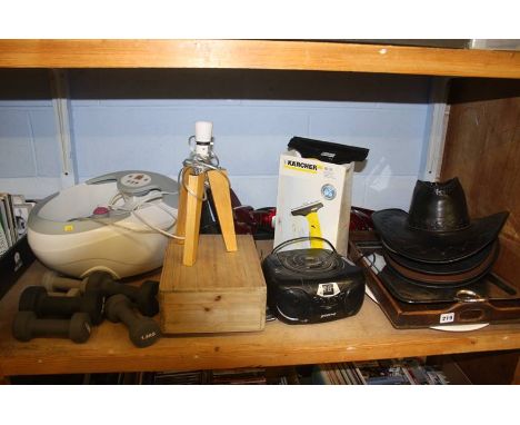 A shelf of miscellaneous including a footbath and a selection of hats