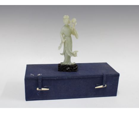 A carved jade figure of Guanyin, 20th century, standing holding a fan, upon a wooden stand, with box, 19cm including stand