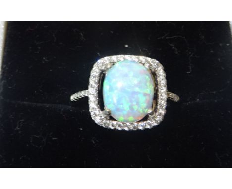 A silver Dress Ring set with an opal surrounded by cubic zirconias.