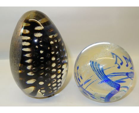 A Caithness Rhythm n Blues pattern paperweight and a Phoenix Art glass paperweight. 