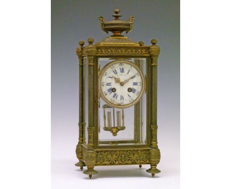 Late 19th/early 20th Century French brass cased four glass mantel clock, surmounted with a classical urn, a pillar to each co