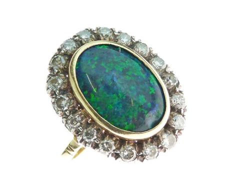 Black opal and diamond cluster ring, stamped '18ct', the oval shallow cabochon approximately 15.5mm x 11mm x 3mm deep, of pre