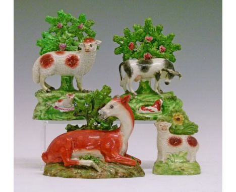 Four early 19th Century Staffordshire animal bocage figures comprising: Deer 12.5cm high, Cow 15.5cm high and two Sheep 9.5cm