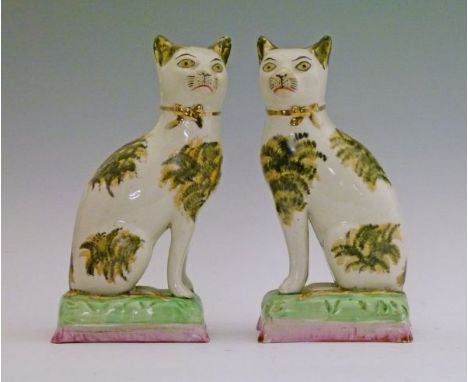 Pair of 19th Century Staffordshire pottery figures of seated cats, each having tortoiseshell markings, gilt collar and standi