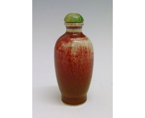 Chinese Jun glazed porcelain snuff bottle having a green hardstone stopper, overall height 8.5cm  Condition: Some crazing and