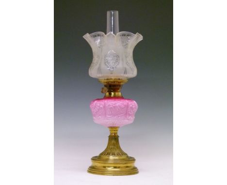 Victorian oil lamp, the pink glass shade having embossed stylised foliate decoration, flared brass pillar and circular foot w