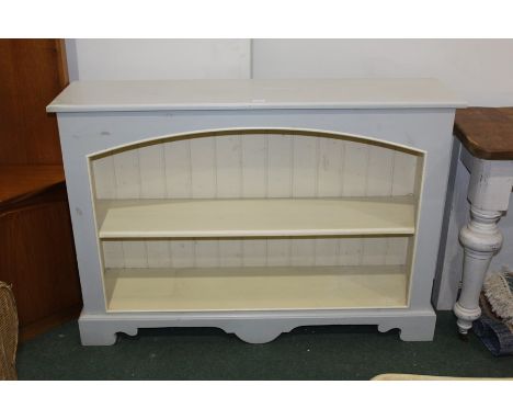 Open bookcase, painted light blue and cream, with arched opening, on bracket feet, 121.5cm wide