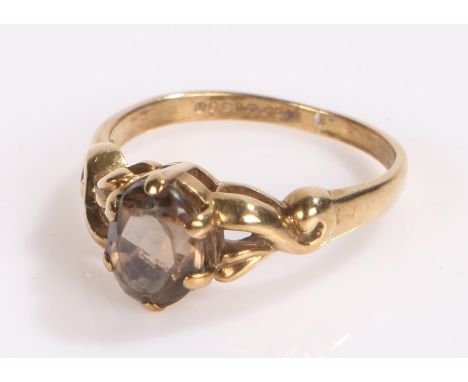 9 carat gold ring the scroll shoulders with a smoky quartz to the head, ring size K 1/2
