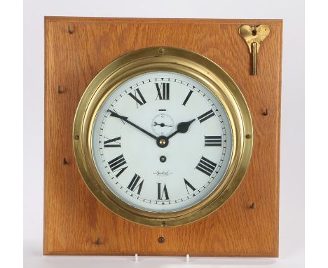 Brass ships clock, Sestrel, with a white enamel dial, Roman hours and subsidiary seconds, mounted on an oak board, the dial 1