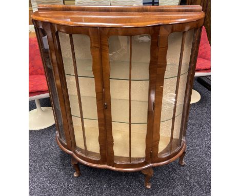 20th century bow front walnut cabinet, two framed glass doors leading to glass shelf interior, raised on short cabriole legs 