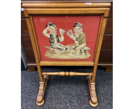 Oak firescreen with centre tapestry depicting a card game between two, on trestle feet with turned supporting stretcher