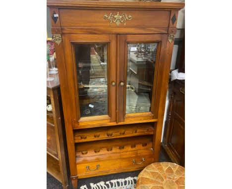 A contemporary display unit with two glass paneled doors leading to a glass shelf interior, above a two tier drinks rack and 