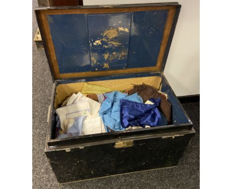 Antique metal travel trunk containing various linen and tapestry items 