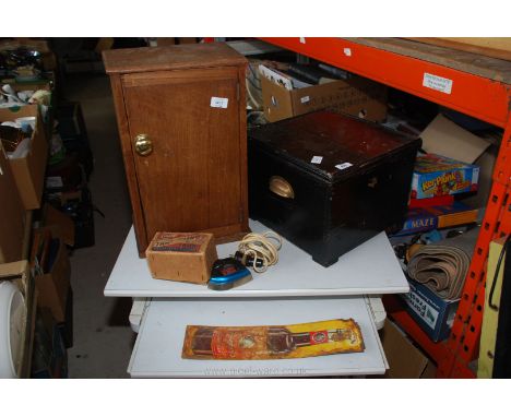 A small boxed travel iron, enamel sauce sign, wooden painted box and wooden cabinet.