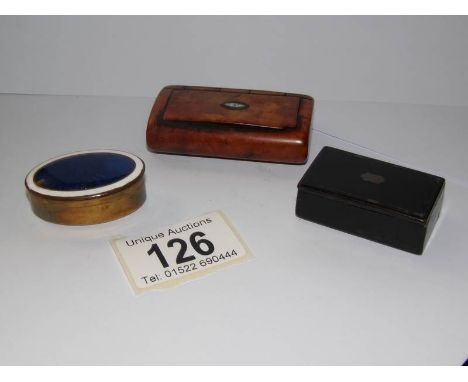 A red fruitwood snuff box, a lacquered snuff box and a blue enamel pill box