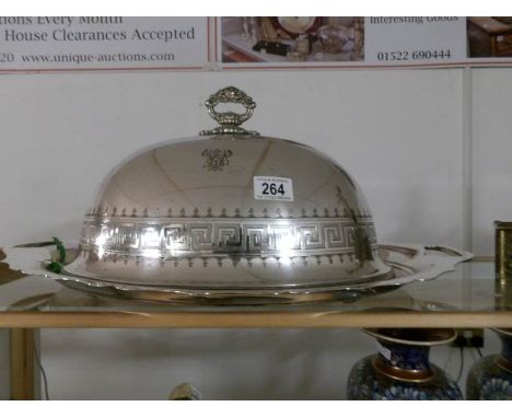 A large silver plated food dome on stand