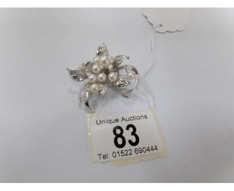 A silver brooch set cultured pearls fashioned as a spray of flowers with 9 pearls