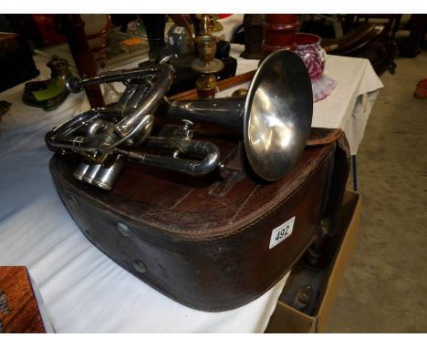 A cased silver plated trumpet with mouthpiece and stands