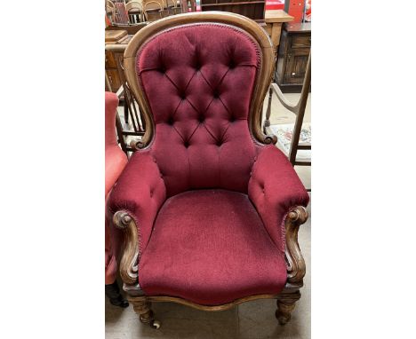 A Victorian mahogany framed gentleman's chair with a button back upholstered spoon back with pad arms and seat on turned legs