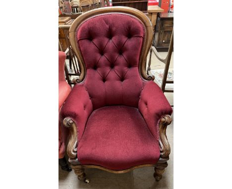 A Victorian mahogany framed gentleman's chair with a button back upholstered spoon back with pad arms and seat on turned legs