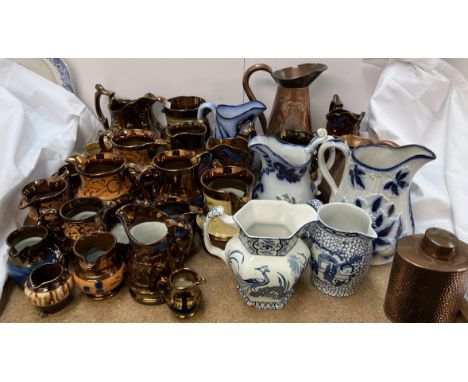 An Art Nouveau copper jug together with another copper jug, copper tea caddy, copper lustre jugs, blue and white and other po