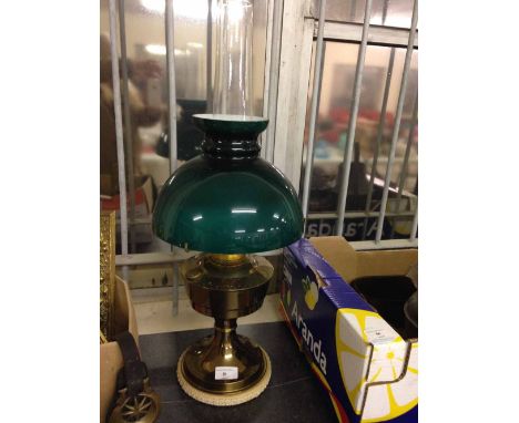 A brass oil lamp with green glass shade.  